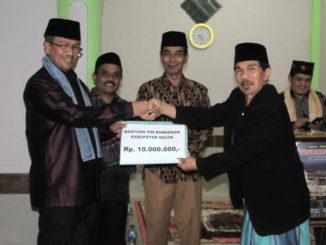 Bupati Gusmal menyerahkan bantuan ke pengurus Mushalla Nurul Falah.