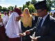 Bupati Indra Catri menyerahkan blanko KIA kepada salah seorang murid SD.