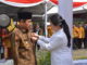 Bupati Sijunjung Yuswir Arifin tengah disematkan tsnda kehormatan Satyalencana oleh Menko PMK, Puan Maharani.