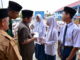 Bupati Sijunjung Yuswir Arifin (kiri) tengah menyerahkan bantuan dana pendidikan yang berasal dari Baznas untuk siswa kurang mampu.