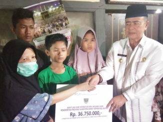 Wagub Nasrul Abit saat menyerahkan bantuan.