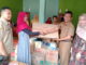 Kepala Dinas Sosial Pemberdayaan Perempuan dan Perlindungan Anak, Yofritas tengah menyerahkan peralatan memasak.