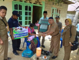 Tim dari Dinas Sosial PP & PA Kabupaten Sijunjung tengah menyerahkan bantuan sosial bagi penyandang disabilitas.