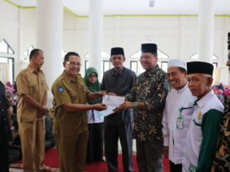 Bupati Irfendi Arbi didampingi ketua BAZNAS Desembri P Caniago dserahkan bantuan sekolah anak kurang mampu secara simbolis.