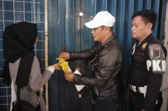 Proses membuka segel toko oleh satuan pengamanan Pasar Aur disaksikan pemilik atau karyawan toko