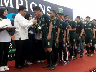 Sekdako Sony mengalungkan medali emas kepada tim Kelurahan Balai Balai