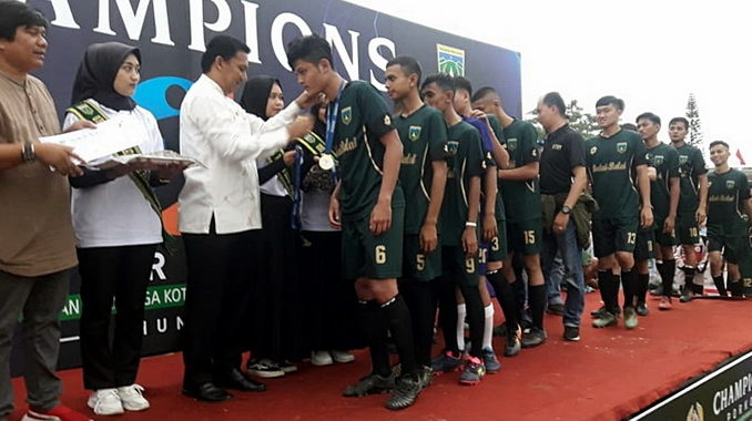 Sekdako Sony mengalungkan medali emas kepada tim Kelurahan Balai Balai