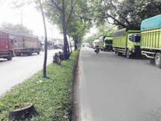 Truk yang parkir sepanjang jalan raya Indarung.