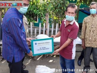 Walikota Sawahlunto saat menyerahkan bantuan terhadap salah seorang warga Kelirahan Pasar.
