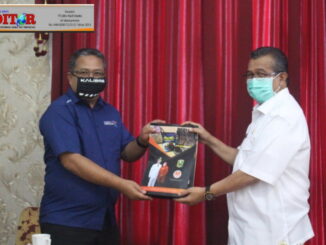 Bupati Gusmal saat menyerahkan cendra mata.