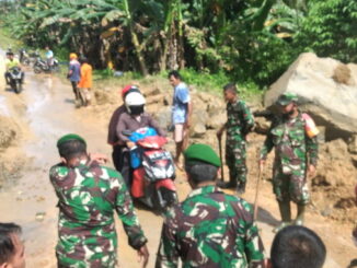 Personil kodim 0319 Mentawai, bersama BPBD Mentawai dan masyarakat desa Goisooinan turun kelokasi longsor membersihkan tumpukan batu dan tanah di ruas jalan umum.