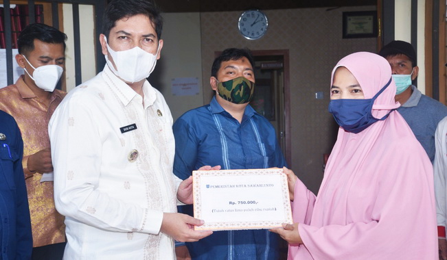 Walikota Sawahlunto menyerahkan bantuan.