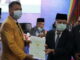 Bupati Ali Mukhni menyerahkan sertifikat tanah kepada Wakil Rektor II UNP.