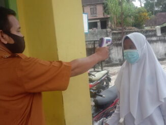 Pengecekan suhu tubuh siswa sebelum melaksanakan ujian.