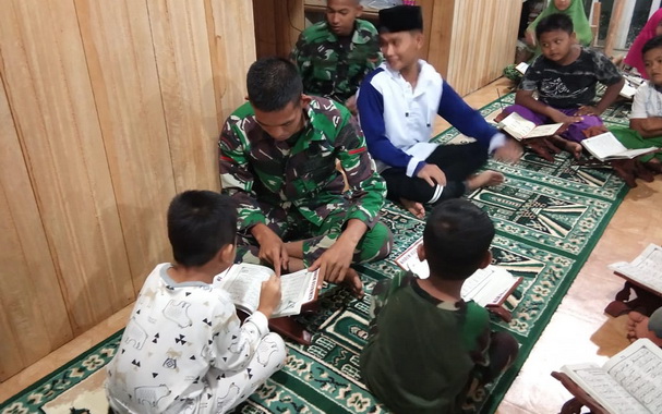 Tim Satgas TMMD Mentawai mengajr anak-anak mengaji Al Gur'an.