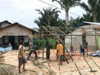 Anggota Satgas TMMD saat ikut memasang tenda di Mapadegat.