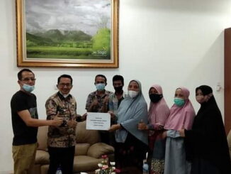 Bupati Eka Putra menyerrahkan bantuan modal kepada pedagang pabukoan secara simbolis.