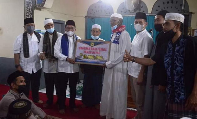 Bupati Eka Putra saat menyerahkan bantuan.