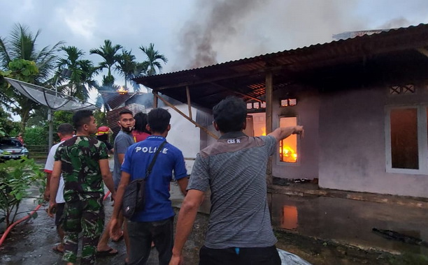 Petugas Damkar Payakumbuh tengah berupaya memadamkan api yang melalap rumah Sari.