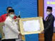 Pj. Bupati Heri Nofiardi saat menerima penghargaan TP2DD.