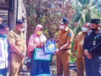 Walikota Sawahlunto menyerahkan bantuan disaksikan oleh Kepala Dinas Sosial dan Ketua BazNas Kota Sawahlunto.