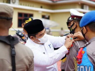 Pemasangan pita oleh Bupati Suhatri Bur kepada salah seorang anggota Polres Padang Pariaman sebagai pertanda dimulai operasi Ketupat Singgalang tahun 2021.