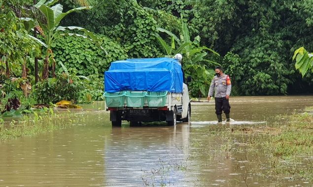 Petugas polisi saat memandu kenderaan di daerah yang kena banjir.