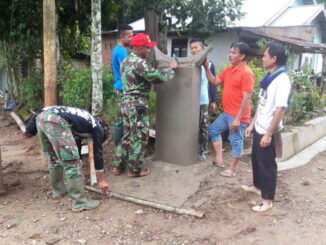 Goro personil satgas TMMD bersama masarakat membuat tugu TMMDN.