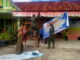 Anggota satgas TMMD membantu pihak sekolah melakukan berbagai kegiatan,ternasuk memasang spanduk.