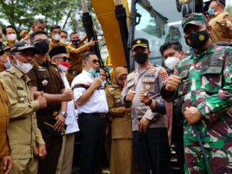Bupati Epyardi Asda menyerahkan ekskavator.