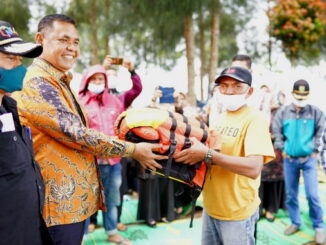 Bupati Epyardi Asda saat menyerahkan bantuan.