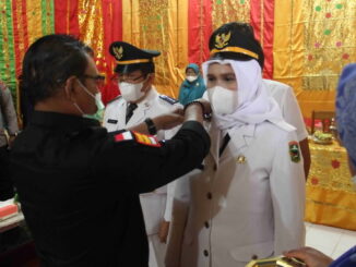 Edisar memasangkan tanda pangkat kepada camat yang baru.