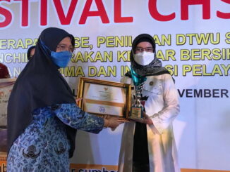 Sekdako Sawahlunto saat menerima piagam penghargaan.