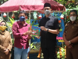 Wako Bukittinggi menyerahkan bantuan buku dari Kepmen PPPA kepada pengelola taman baca Mutiara Hati.