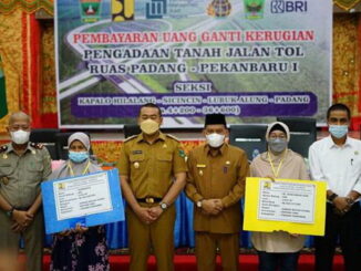 Wagup Sumbar Audy Joinaldy dan Wabup Padang Pariaman Rahmang bersama dengan dua warga masyarakat penerima ganti rugi .