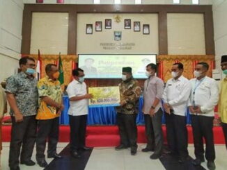 Anggota DPR RI Dapil Sumbar dari Fraksi Partai Golkar Jon Kenedi Azis secara simbolis menyerahkan bantuan kepada Bupati Padang Pariaman Suhatri Bur.