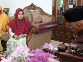 Gubernur Mahyeldi menandatangani buku karya Melani.