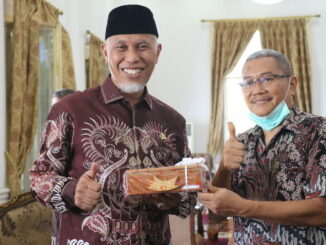 Gubernur Mahyeldi saat menerima hadiah.