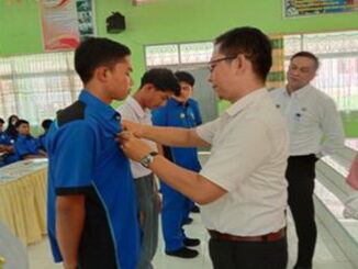 Iyus.M.Eng Kasi SMK Kacabdin Pendidikan Sumbar Wilayah IV Payakumbuh menyematkan tanda peserta PKL.