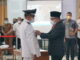 Bupati Eka Putra memasang atribut wali nagari kepada salah sorang yang dilantik.