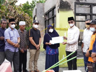Bupati Safaruddin saat menyerahkan bantuan.