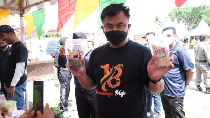 Bupati Sutan Riska dengan minyak goreng kemasan yang akan dijual pada operasi pasar.