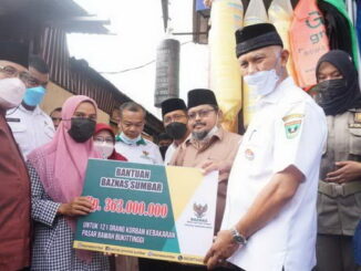 Gubernur Mahyeldi saat menyerahkan bantuan.