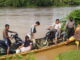 Warga Siguntur yang terpaksa menyeberang dengan sampan karena tidak adanya jembatan.