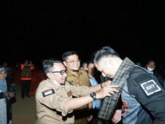 Bupati Eka Putra mengalungkan kain sarung kepada AHY.