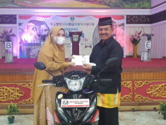 Fauzi Bahar saat memberikan hadiah sepeda motor secara simbolis.