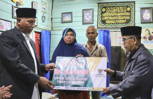 Gubernur Mahyeldi menyerahkan bantuan untuk rehab rumah tak layak huni.