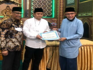 Ketua TSR XI Sumbar menyerahkan bantuan untuk masjid Tangah Jua disaksikan Wakil Walikota Marfendi.