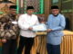 Ketua TSR XI Sumbar menyerahkan bantuan untuk masjid Tangah Jua disaksikan Wakil Walikota Marfendi.
