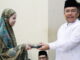 Sekdaprov Sumbar saat menyerahkan bantuan Al Qur'an.
